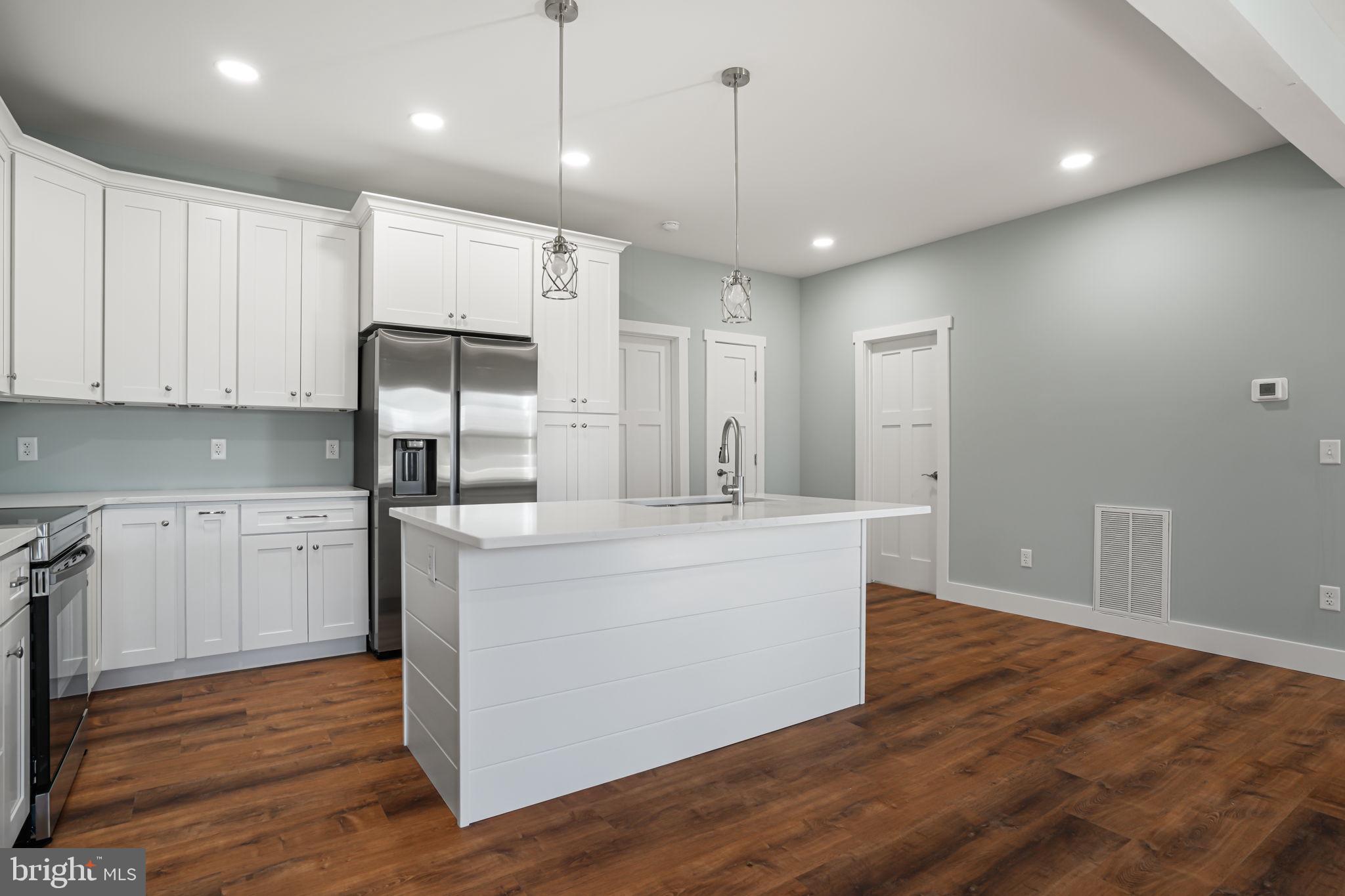 7921 East Side Road Chincoteague Island, VA 23336 - Photo 10 of 38 a large kitchen with stainless steel appliances a large counter top and a refrigerator