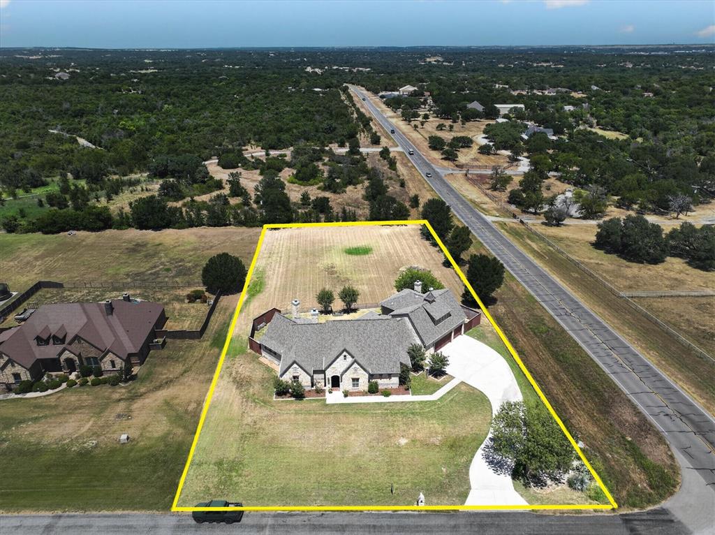 100 Canyon Ridge Trail Aledo, TX 76008 - Photo 37 of 38 Expansive property featuring a stone and brick exterior, multi-gabled roofline, attached garages, and a curved paved driveway