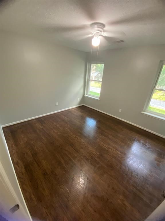5710 Glenmere Lane Spring, TX 77379 - Photo 7 of 9 an empty room with wooden floor fan and windows