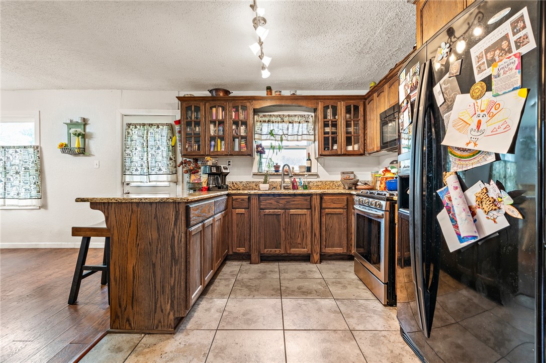 114 Brewster Street Waco, TX 76706 - Photo 8 of 16 a kitchen with stainless steel appliances granite countertop a stove a sink and a refrigerator