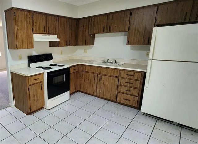 a kitchen with a cabinets sink and white stainless steel appliances