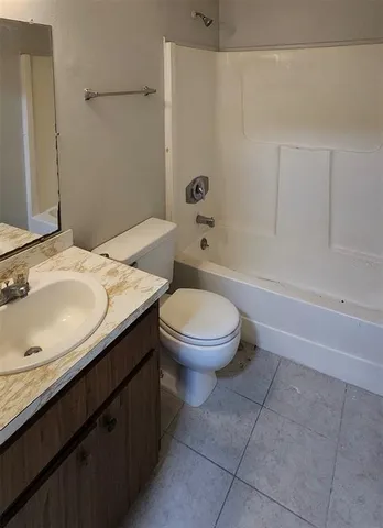 a bathroom with a granite countertop toilet a sink and bathtub