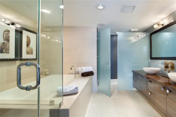 a bathroom with a double vanity sink a mirror and shower