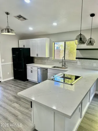 a kitchen with stainless steel appliances granite countertop a sink a stove and a refrigerator