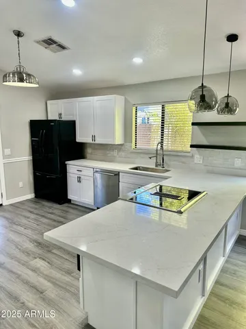 a kitchen with stainless steel appliances granite countertop a sink a stove and a refrigerator