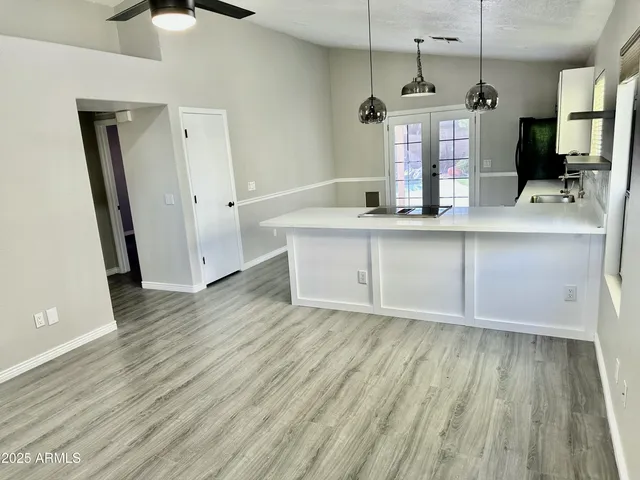 a view of a kitchen with wooden floor and a sink