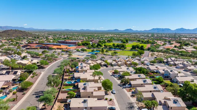 an aerial view of a city with lots of residential buildings and mountain view in back
