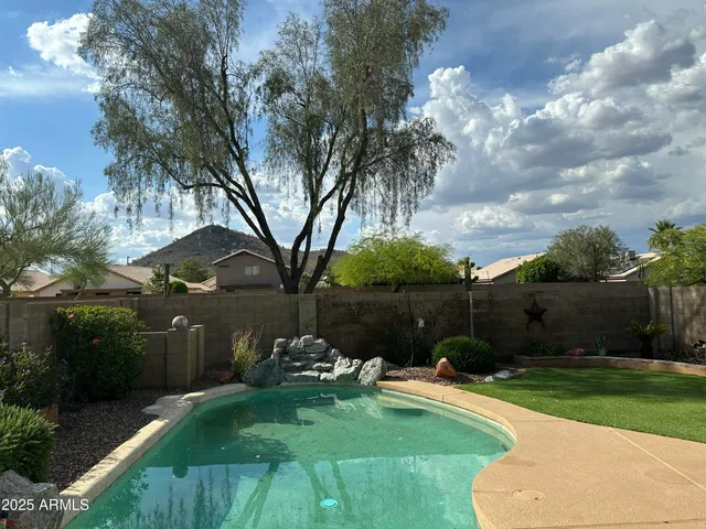 a backyard of a house with lots of green space and fountain