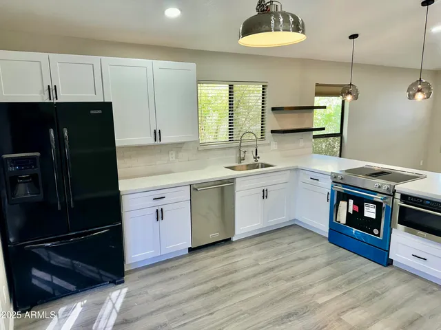 a kitchen with stainless steel appliances a stove a sink and a refrigerator