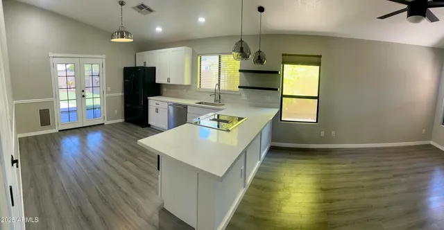 a kitchen with stainless steel appliances granite countertop a sink a stove and a wooden floors