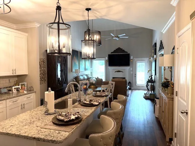 a living room with furniture kitchen view and a chandelier