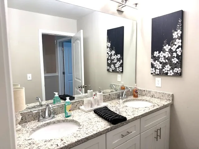 a bathroom with a granite countertop sink and a mirror