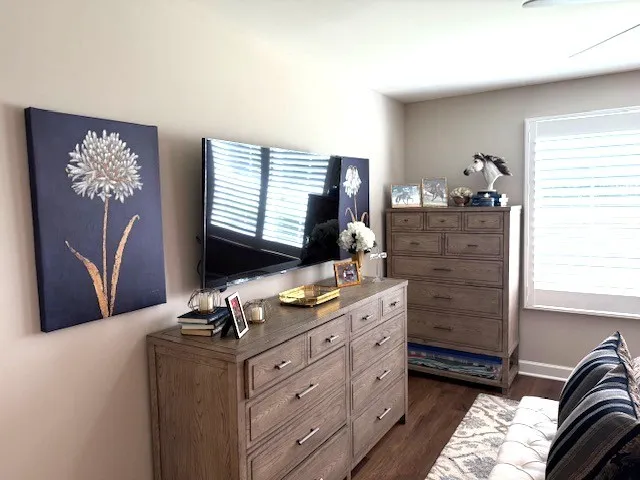 a room with a bed dresser and a window