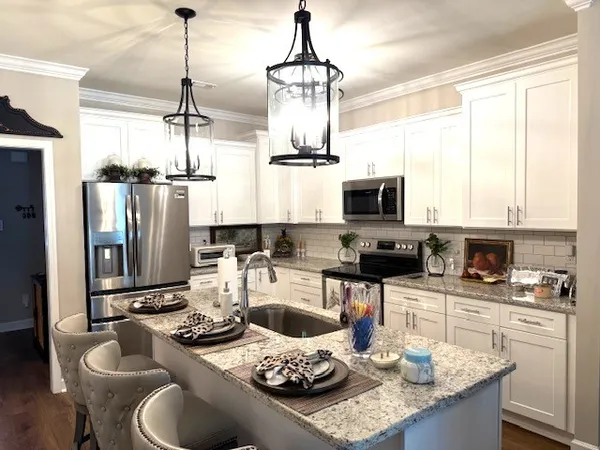 a kitchen with a sink a stove and chairs