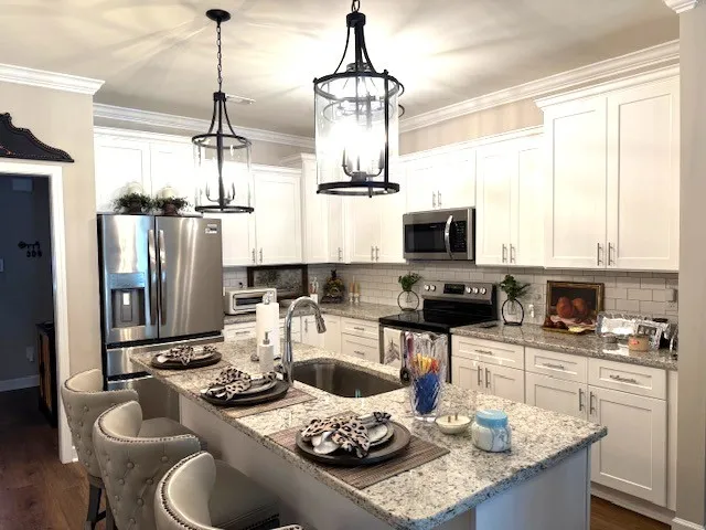 a kitchen with a sink a stove and chairs
