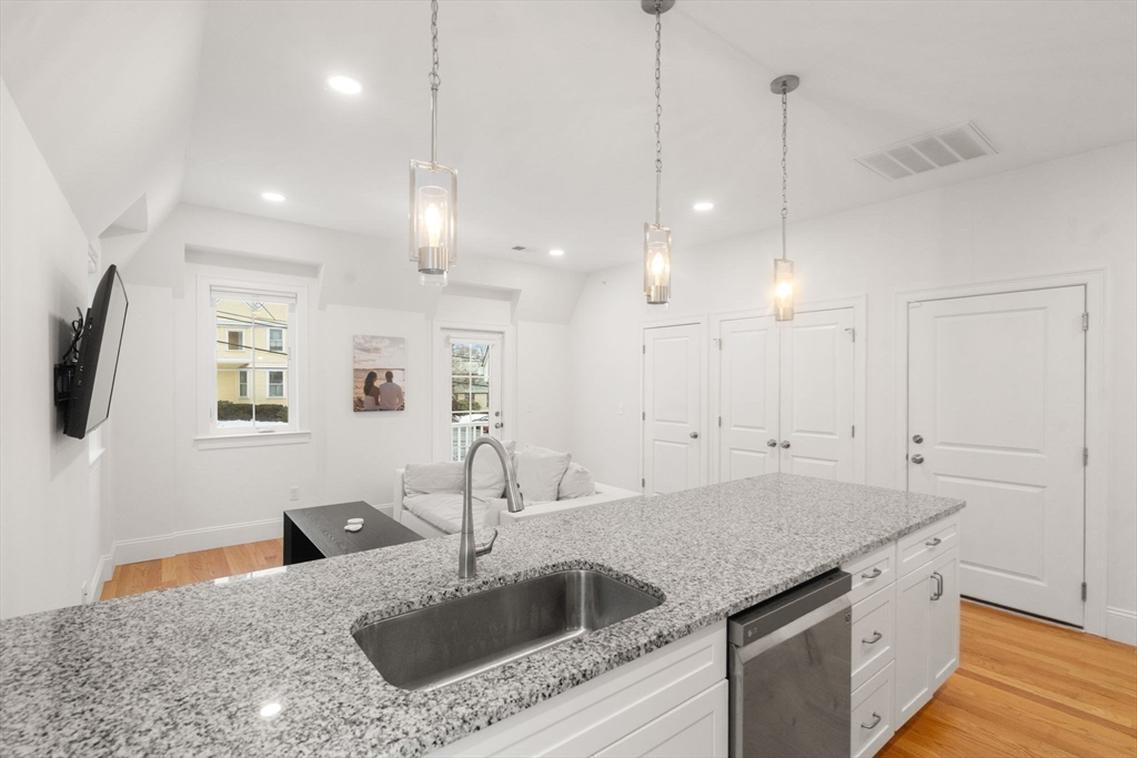 68 Chestnut Street, Unit 6 Newton, MA 02465 - Photo 11 of 22 a kitchen with a sink a faucet a chandelier and living room view