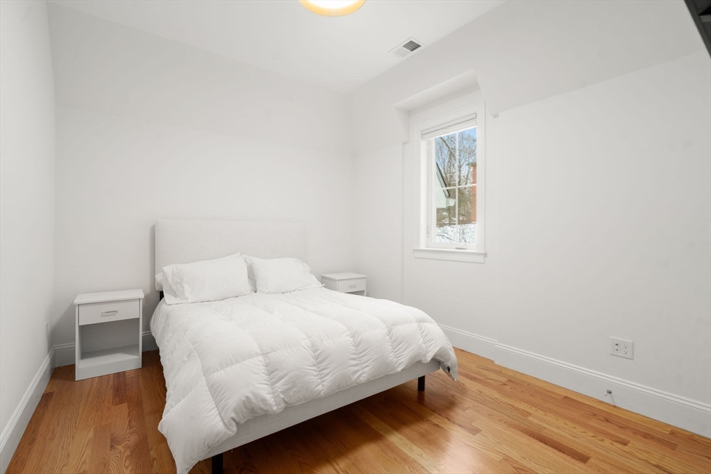 68 Chestnut Street, Unit 6 Newton, MA 02465 - Photo 13 of 22 a bedroom with a bed and wooden floor