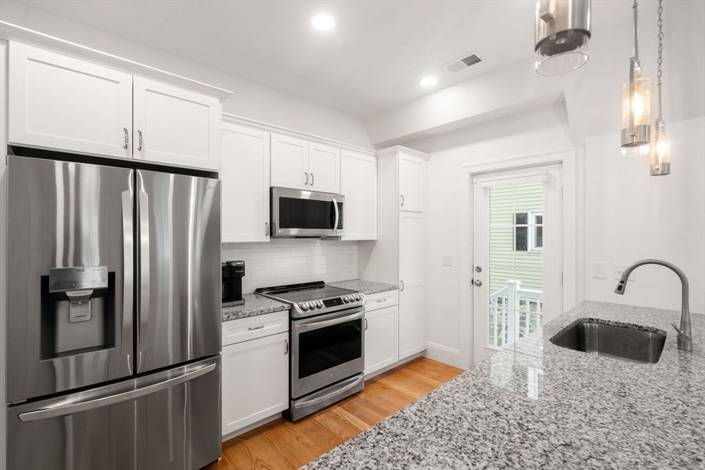 68 Chestnut Street, Unit 6 Newton, MA 02465 - Photo 9 of 22 a kitchen with stainless steel appliances a refrigerator sink and microwave
