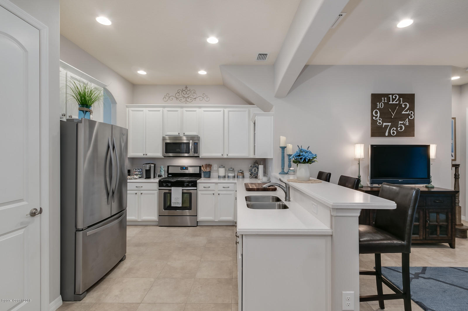 3225 Sedge Drive Rockledge, FL 32955 - Photo 8 of 35 a kitchen with a refrigerator a stove a microwave oven a sink and chairs