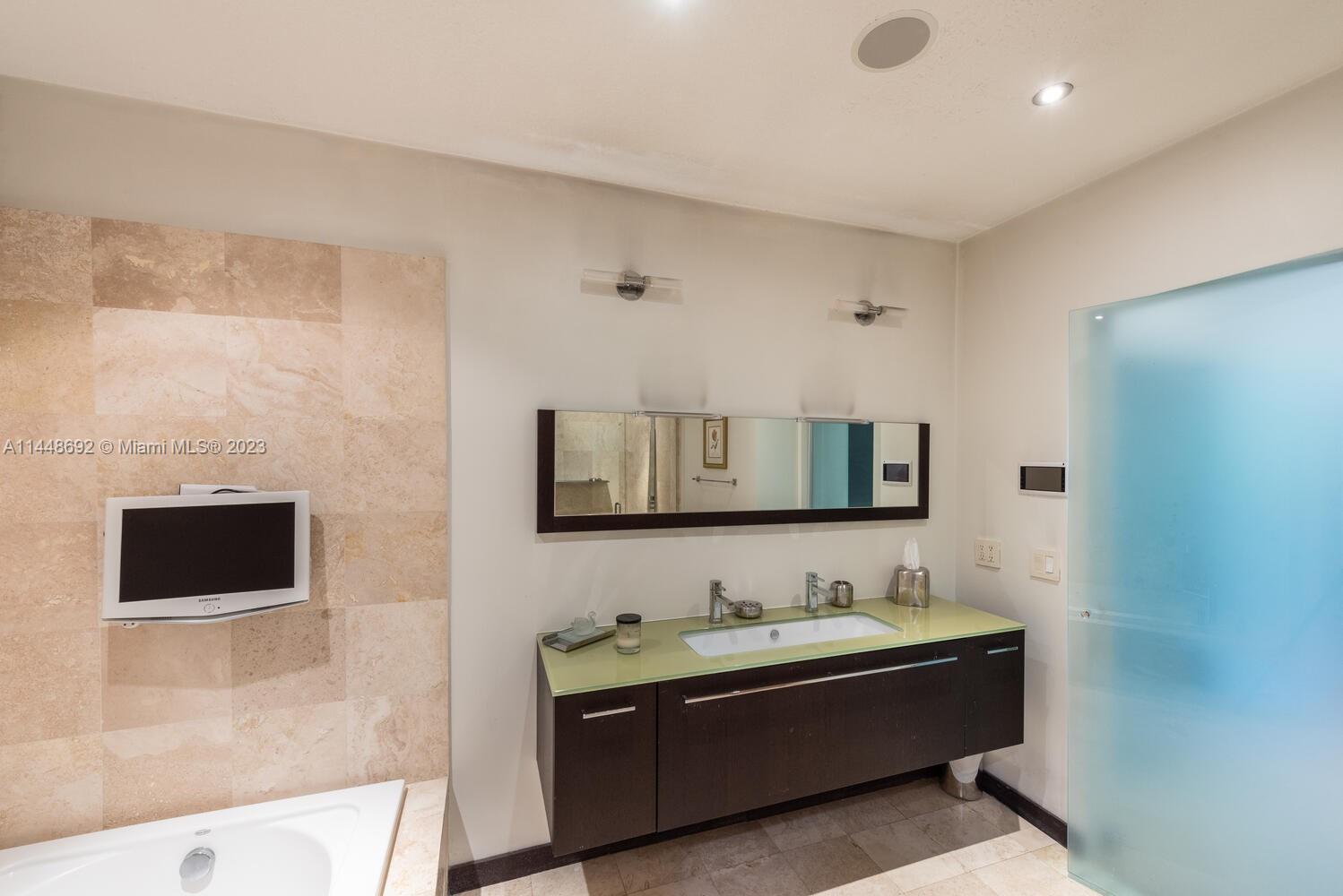 2401 Anderson Road, Unit 3 Coral Gables, FL 33134 - Photo 20 of 46 a bathroom with a tub sink and mirror