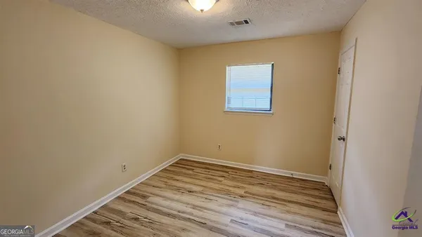 a view of a room with wooden floor and white walls
