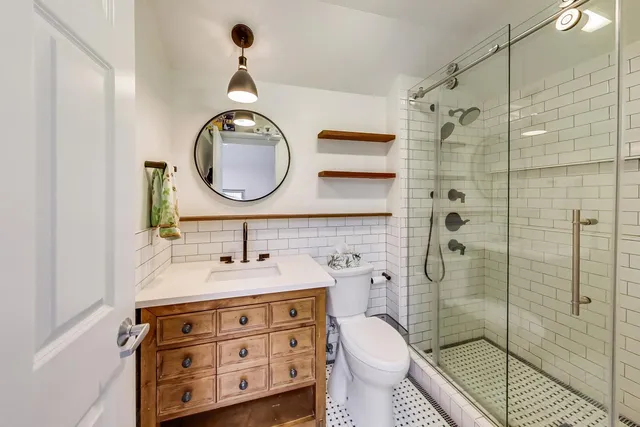 a bathroom with a sink a toilet and shower