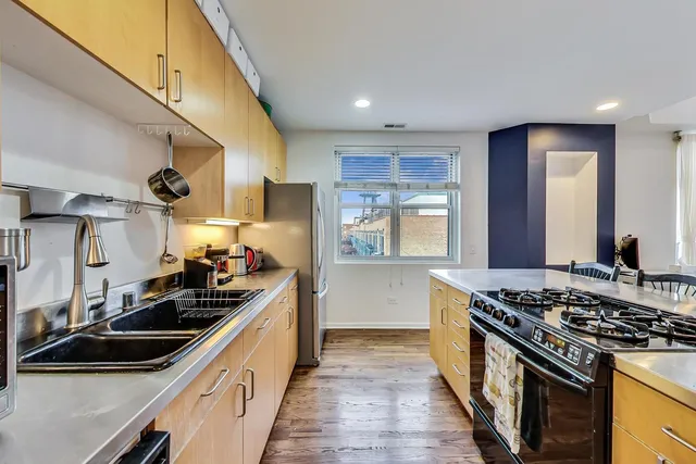 a kitchen with sink stove and refrigerator