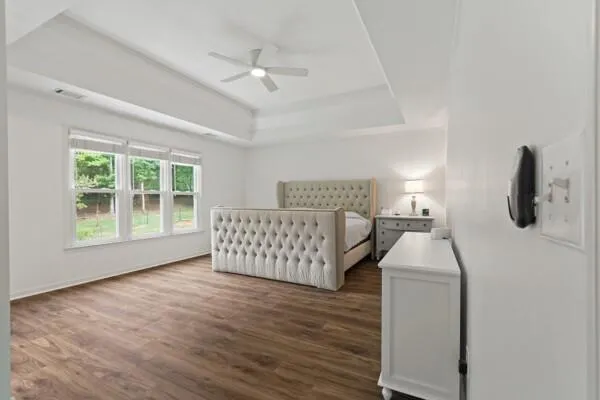 a bedroom with a bed and wooden floor
