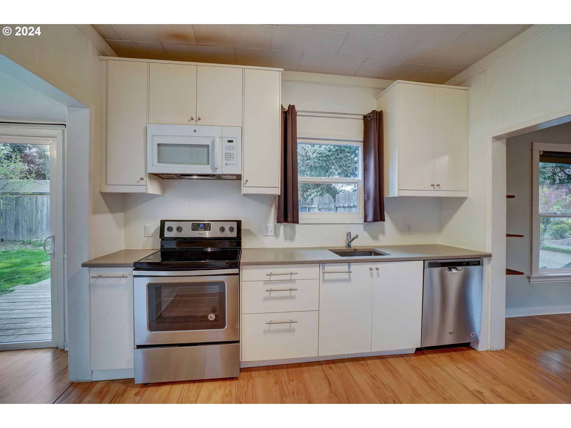 1248 North Watts Street Portland, OR 97217 - Photo 17 of 36 a kitchen with stainless steel appliances granite countertop a stove a sink and a microwave