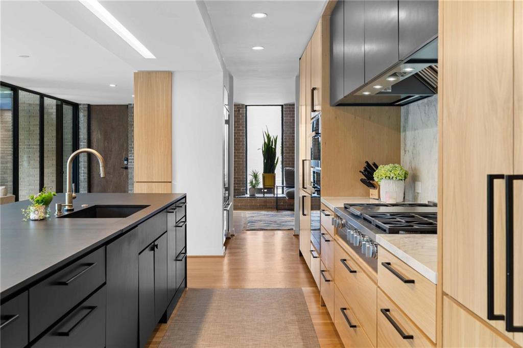 1671 Friar Tuck Road Northeast Atlanta, GA 30309 - Photo 19 of 63 a kitchen with stainless steel appliances a sink stove and cabinets