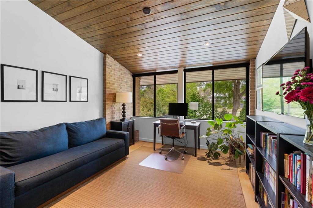 1671 Friar Tuck Road Northeast Atlanta, GA 30309 - Photo 32 of 63 a living room with furniture a flat screen tv and a large window