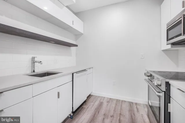 a kitchen with a sink a microwave and cabinets