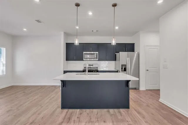 a kitchen with kitchen island a sink and a stove top oven