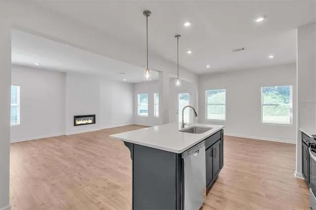 a kitchen with a sink chandelier and living room view