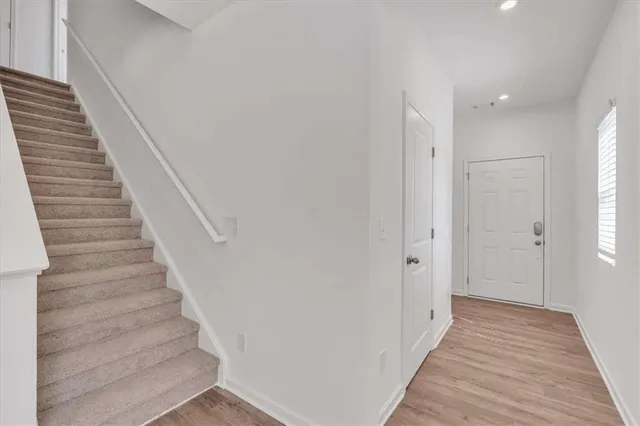 a view of a hallway with wooden floor and entryway