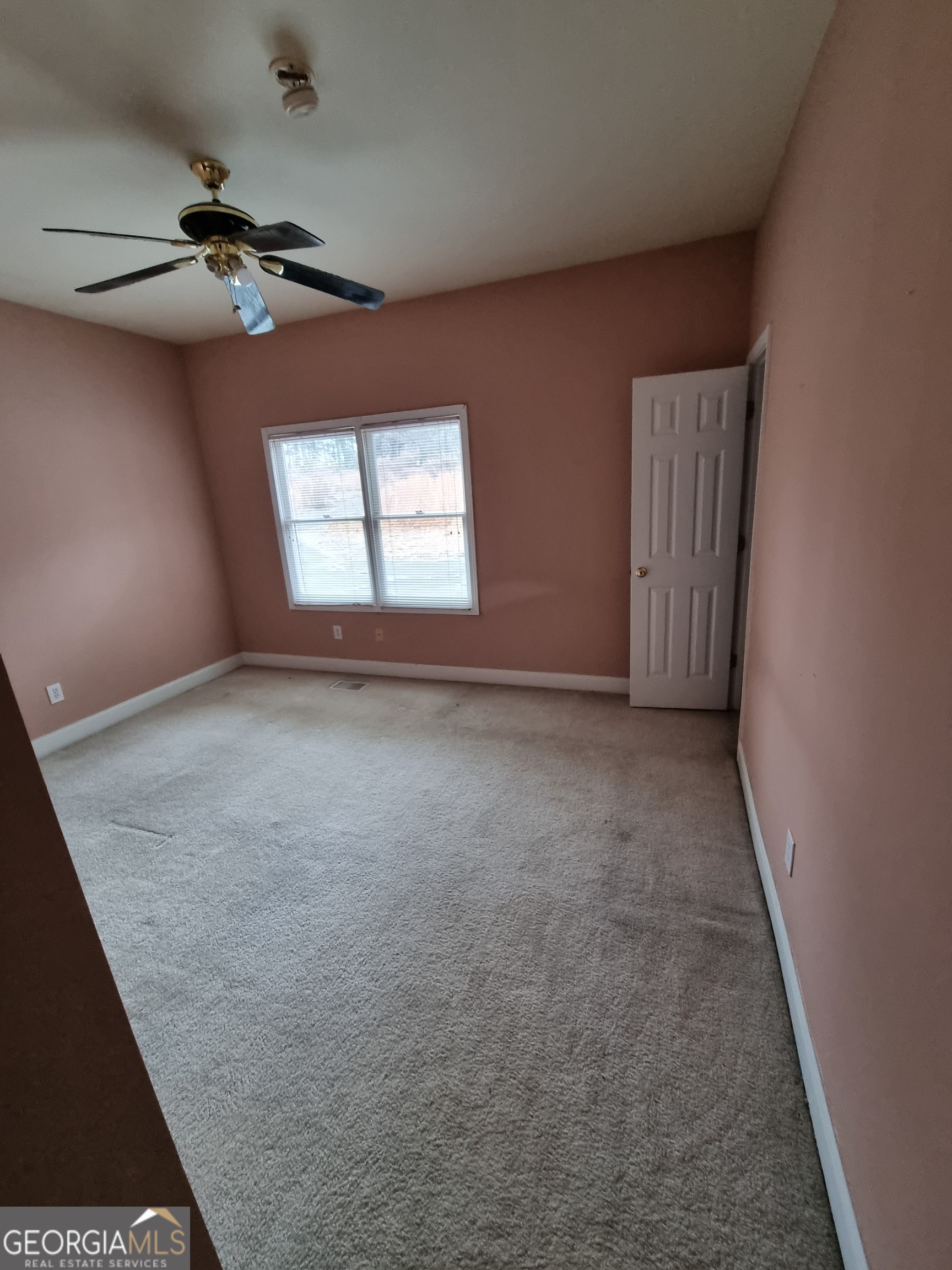 6235 Short Road Fairburn, GA 30213 - Photo 12 of 32 an empty room with a chandelier fan and windows