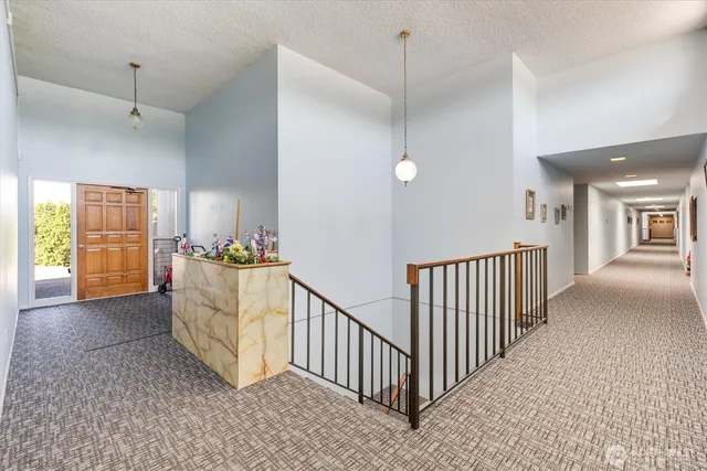 a view of a hallway to room with wooden floor and windows