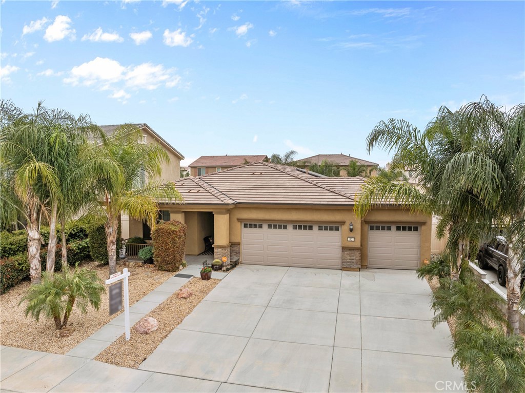 a view of a house with a yard and potted plants