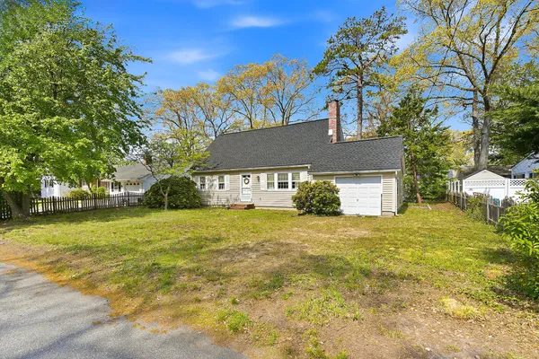 a front view of a house with a yard and trees