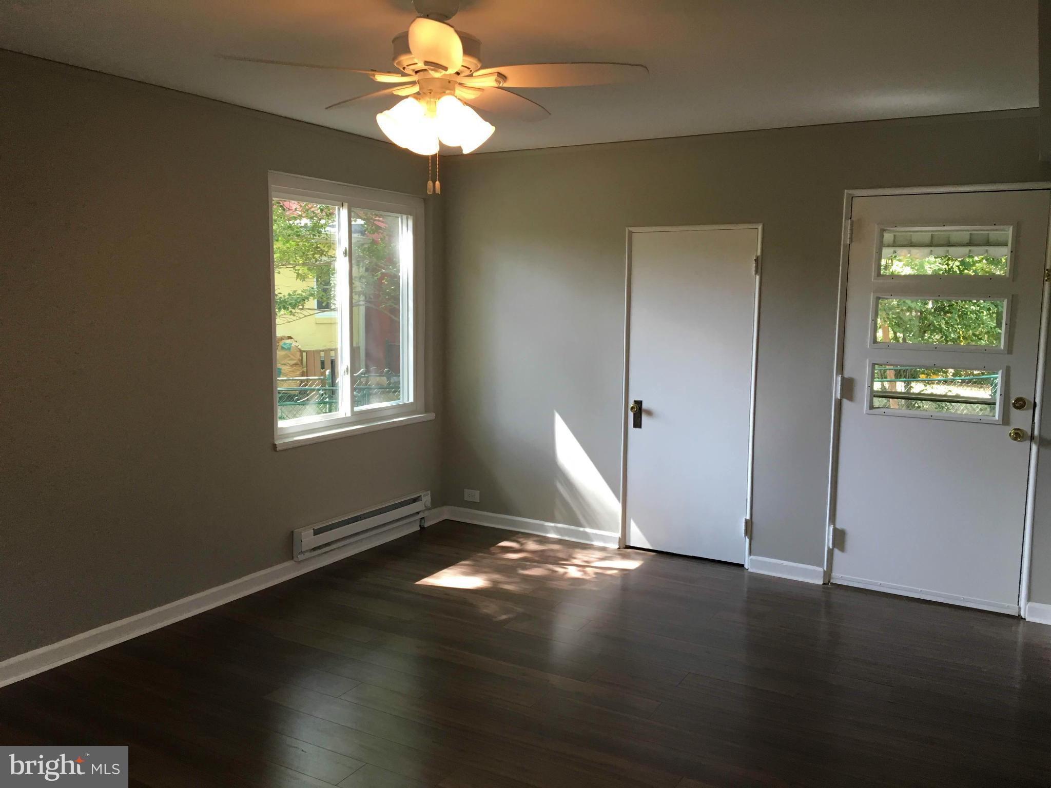 39 Ridge Road, Unit C Greenbelt, MD 20770 - Photo 13 of 22 a view of an empty room with wooden floor and a window
