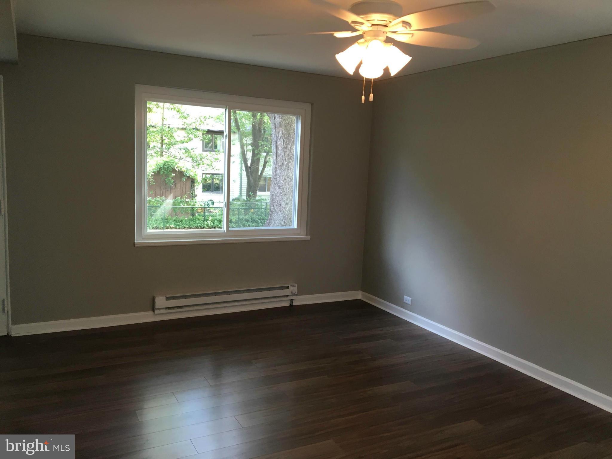 39 Ridge Road, Unit C Greenbelt, MD 20770 - Photo 4 of 22 a view of an empty room with wooden floor and a window