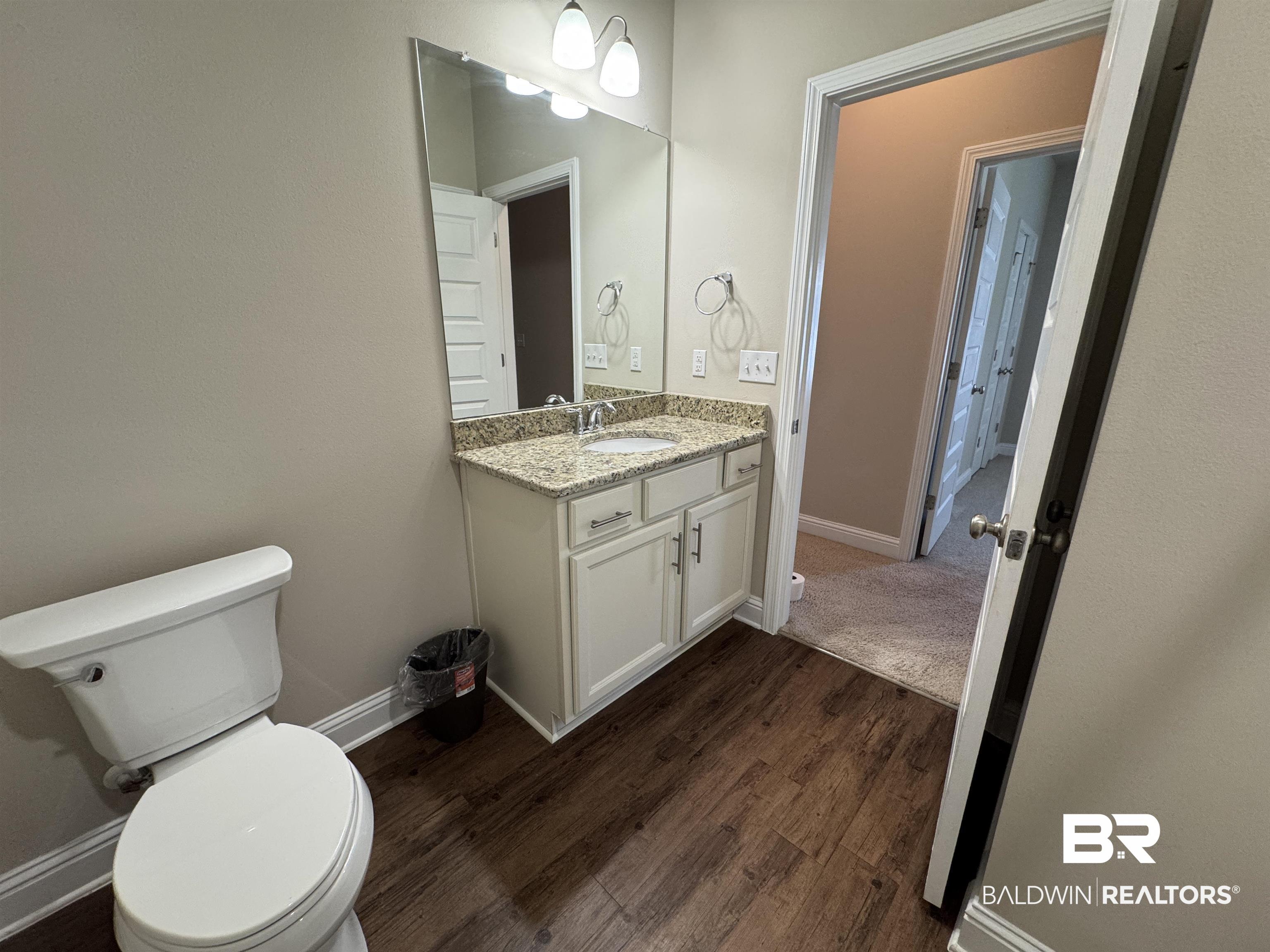 6811 Spaniel Drive, Unit C Daphne, AL 36527 - Photo 19 of 33 Bathroom with toilet, vanity, wood finished floors, and baseboards