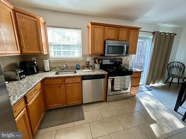 a kitchen with a sink a stove a microwave and wooden cabinets