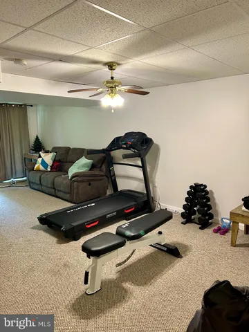 a living room with furniture gym equipment and a rug