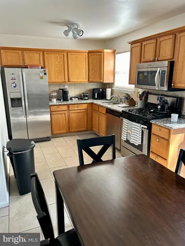 a kitchen with stainless steel appliances granite countertop a sink a stove a refrigerator a microwave oven with a dining table and chairs