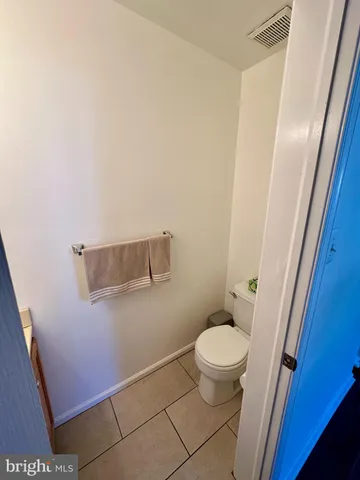 a white toilet sitting next to a white sink and vanity