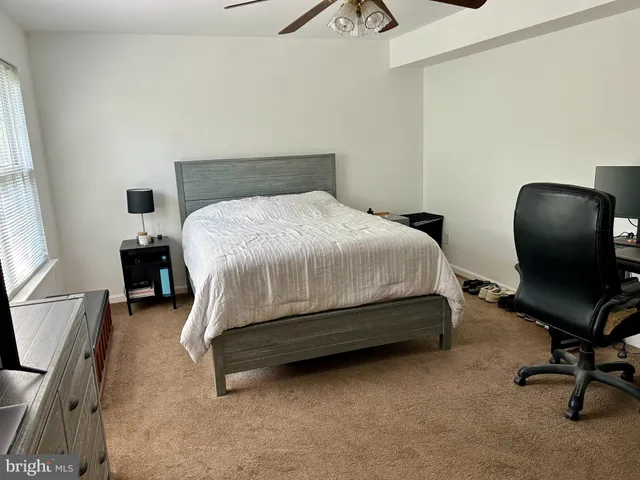a bedroom with a bed chair and a desk