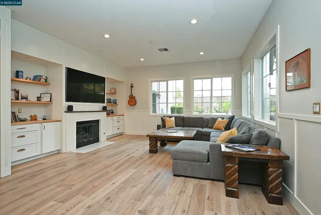 a living room with furniture a flat screen tv and a fireplace