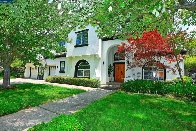 a front view of a house with yard and green space
