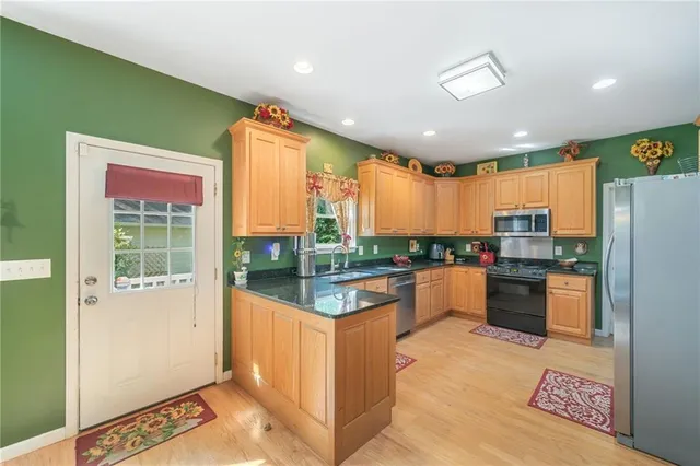 a kitchen with stainless steel appliances kitchen island granite countertop a refrigerator and stove